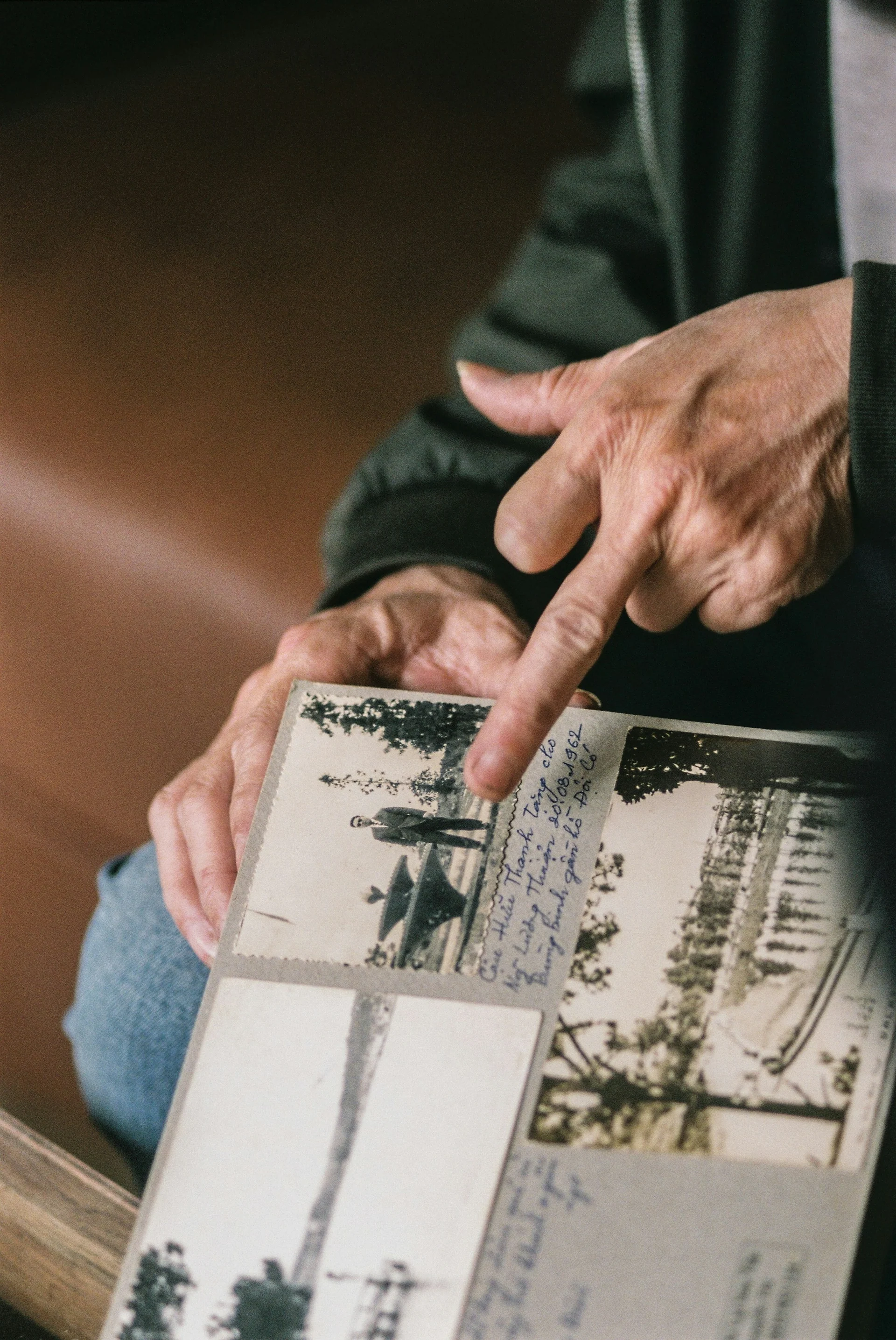 Yaşlı kişi köhnə ailə fotoşəklini göstərir
